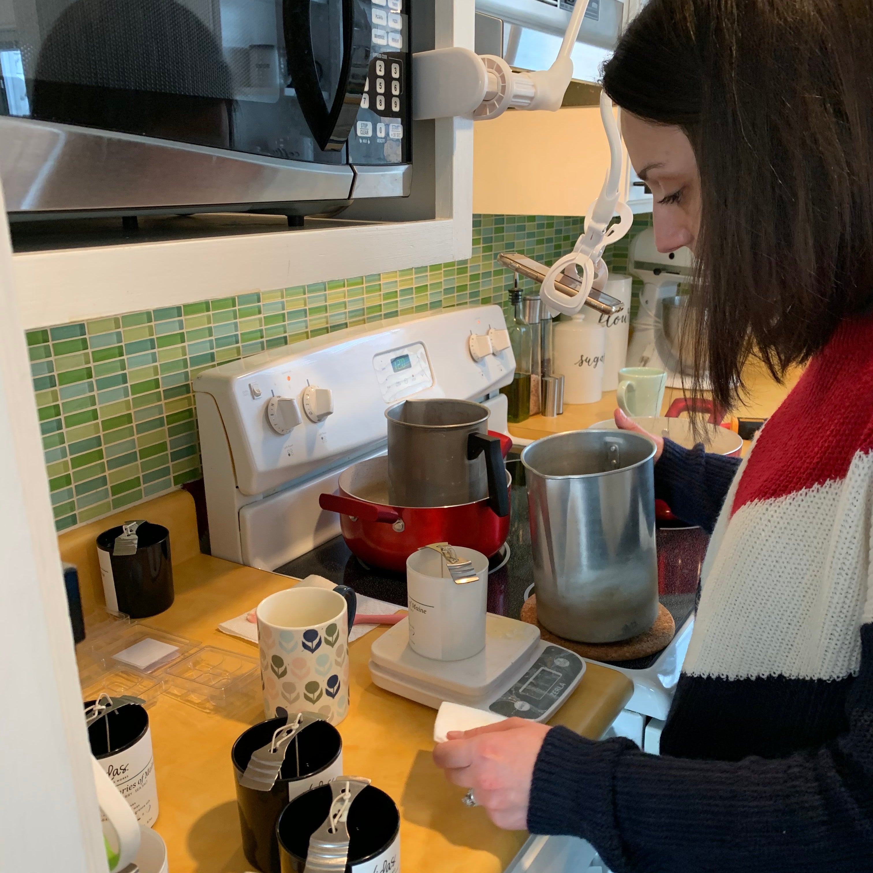 Owner pouring melted wax into candle jars