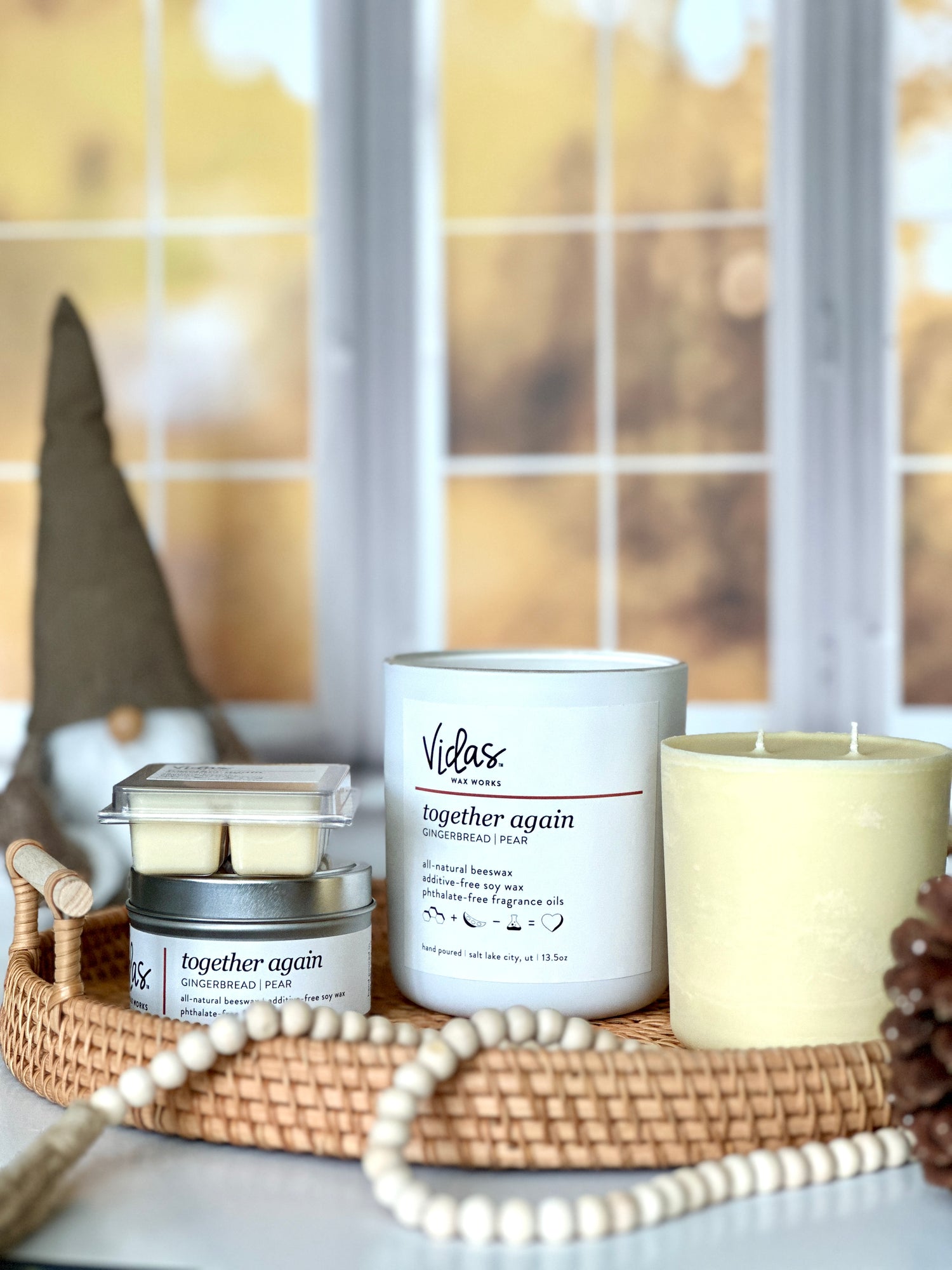 Embrace the autumn ambience with our “Together Again” scent, a delightful blend of gingerbread and pear. Against a backdrop of blurred fall-colored leaves outside a window, the collection features a range of offerings: a 13.5oz candle in a chic matte white jar, a 13.5oz candle refill, a compact 3.5oz candle tin, and dainty 2.5oz wax melts. A symphony of scents to elevate your seasonal moments.