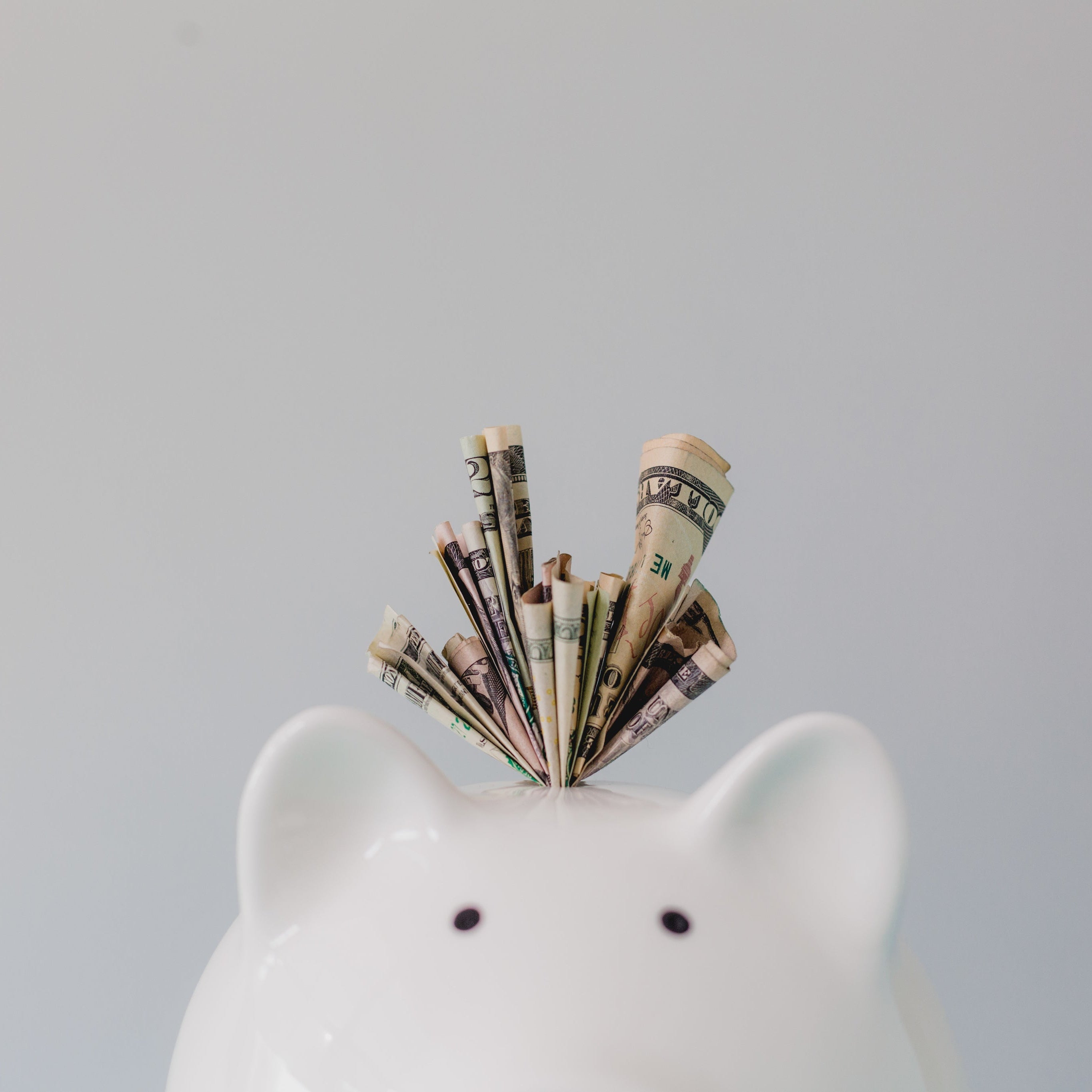 piggy bank with money stuffed inside the top